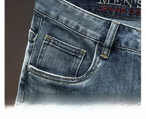 Detail of men's jeans waist with red embroidery and yellow double stitching