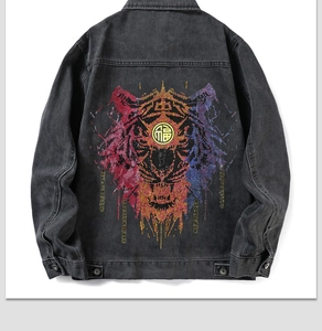 Detail of colorful tiger head motif and 福 character on black denim jacket back