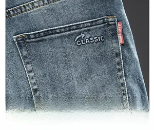 Detailed view of dark blue denim jeans back pocket with Classic embroidery and red label