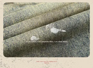 Close-up of vintage denim fabric with white paint spots and 93.9% cotton material details