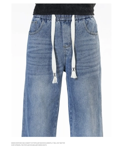 Détail du jean denim délavé bleu clair avec taille élastique et cordon de serrage