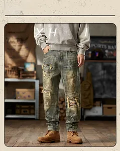 Detail of vintage washed men's jeans with hand-made distressed holes and colorful patches