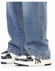 Détail d'un jean en denim clair à jambes larges avec des baskets rétro épaisses