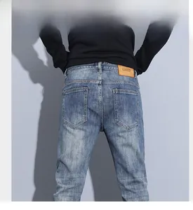 Detail view of denim jeans back with brown leather patch and cat whisker wash effects