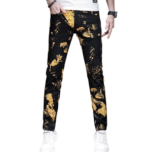 Slim fit men's black jeans with vibrant yellow splatter print on professional model