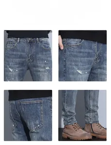 Detail view of washed blue jeans featuring distressed rips and white paint splatters