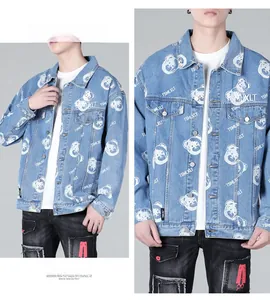 Detail of light blue denim jacket with cartoon bear prints and classic button chest pockets