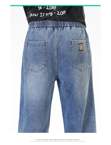 Détail du jean large avec taille élastique et étiquette brodée sur la poche arrière