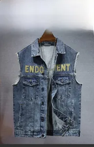 Macro detail of raw hem sleeve and yellow letter print on wash blue denim vest