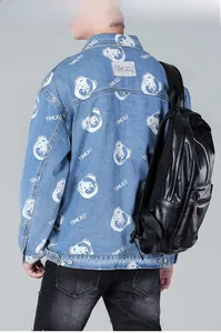 Detail of light blue denim jacket featuring a cartoon bear print and street style graphics