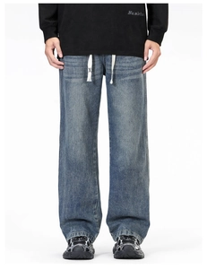 Détail de jean denim large bleu avec cordon blanc et logo X sur l'extrémité