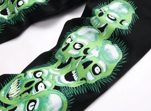 Détail de l'imprimé crâne vert gothique sur un jean skinny noir de style urbain