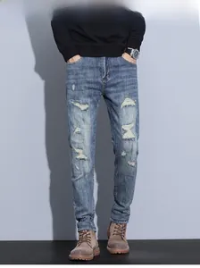 Close-up of vintage light blue slim fit jeans with distressed rips and frayed detailing