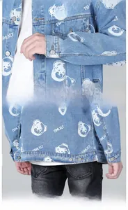Detail of light blue washed denim jacket sleeve cuff and hem with white bear print