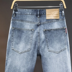 Slim fit European style men's washed blue denim jeans shown from a detailed back view