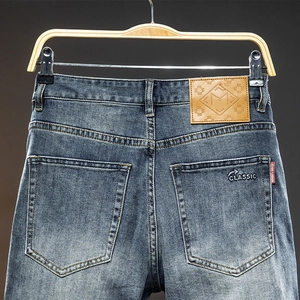 Slim fit men's blue washed denim jeans featuring leather patch and classic embroidery