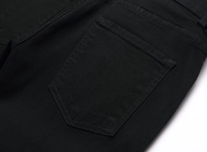 Détail de la poche arrière et de la texture du denim noir sur ce jean gothique à crânes