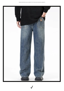 Vue arrière du jean large à jambe droite avec délavage vintage et écusson en cuir orange