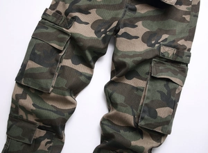 Detailed close-up of woodland camouflage cargo pants with large flap pockets and cotton fabric