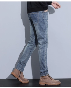 Detail view of vintage blue distressed jeans featuring ripped knees and worn denim texture