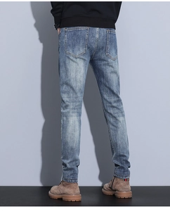 Detail view of men's slim fit jeans showing back pocket and vintage blue wash denim