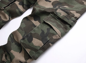 Detailed macro view of heavy-duty woodland camouflage cargo pants with flap pocket design