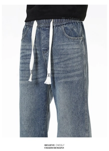 Détail de la taille élastique à cordon sur un jean large bleu délavé pour hommes