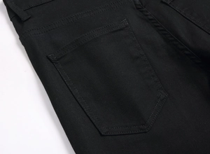 Close-up of black denim jeans rear pocket with double stitching and twill texture
