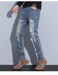 Detail view of vintage distressed denim with ripped knee and slim fit tailored cut