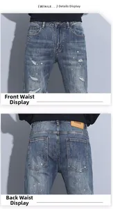 Detail view showing distressed blue wash denim with paint splatters and leather waist label
