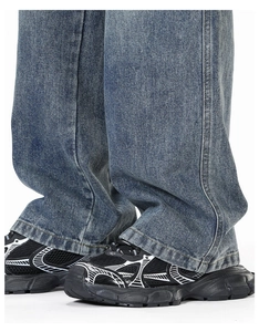 Gros plan détaillé d'un jean en denim bleu large porté avec des baskets rétro noires
