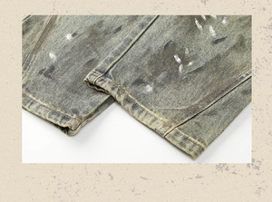 Close-up of vintage mud wash denim jeans with paint splatter and distressed hem details