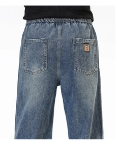 Détail du jean avec taille élastique et écusson numéroté brodé sur la poche arrière du pantalon