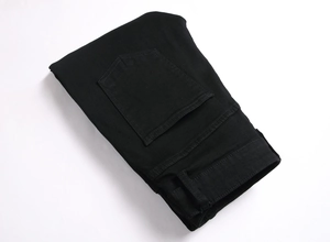 Détail du jean denim à imprimé gothique montrant les poches arrière et les coutures
