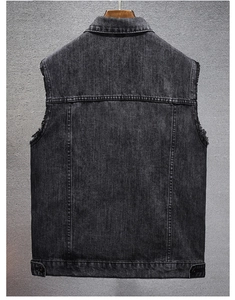 Detail view of denim vest back featuring vintage washed fabric and raw frayed armholes