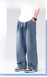 Detail view of baggy straight-leg denim jeans with adjustable white drawstring waist