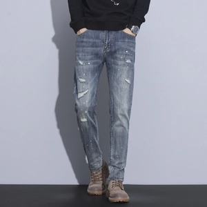 Slim fit men's distressed blue jeans with vintage wash, ripped details and white paint splatters