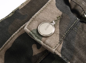 Detail of cargo pants waist with metal jeans button and jungle camouflage twill fabric