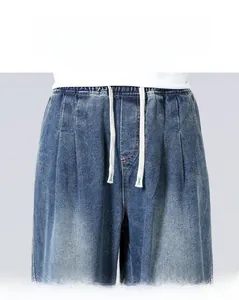 Detail of loose straight-leg denim jeans featuring elastic waist and white cotton drawstring