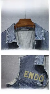 Detail of deep blue denim vest with raw edge sleeve, yellow embroidery and metal buttons