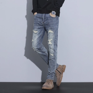 Slim fit men's distressed vintage blue denim jeans with ripped details and tapered leg