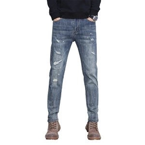 Slim fit men's distressed blue jeans with white paint splatter and tapered leg design