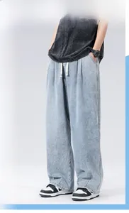 Dettaglio del tessuto denim lavato azzurro su pantaloni maschili a gamba larga rilassati