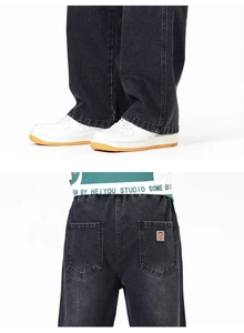 Détail du jean denim gris délavé montrant la taille élastique et l'écusson de poche arrière