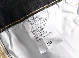 Detailed fabric care label showing 97% cotton blend and size 30 on denim pants