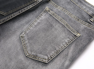 Macro shot of back pocket on dark grey denim jeans with yellow contrast stitching