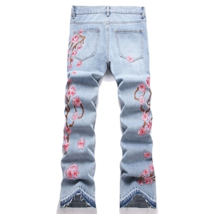 Jean flare bleu pour homme avec broderie cerisier rose et ourlet en V effiloché