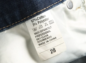 Vue macro de l'étiquette d'entretien du jean flare bleu foncé avec 97% de coton