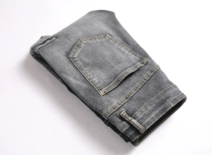 Detail view of contrast stitching and back pockets on gray-black slim fit denim jeans