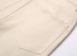 Close-up of durable cream twill denim stitching and pocket detail on punk flare pants